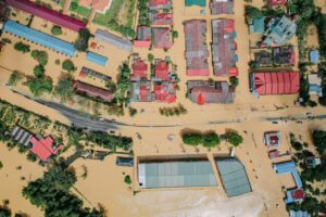 residential houses and green trees in flooded village