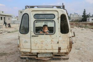 boy sitting in broken car