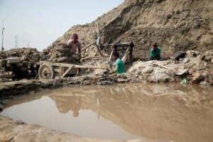 men standing in the mud after a flood in bangladesh