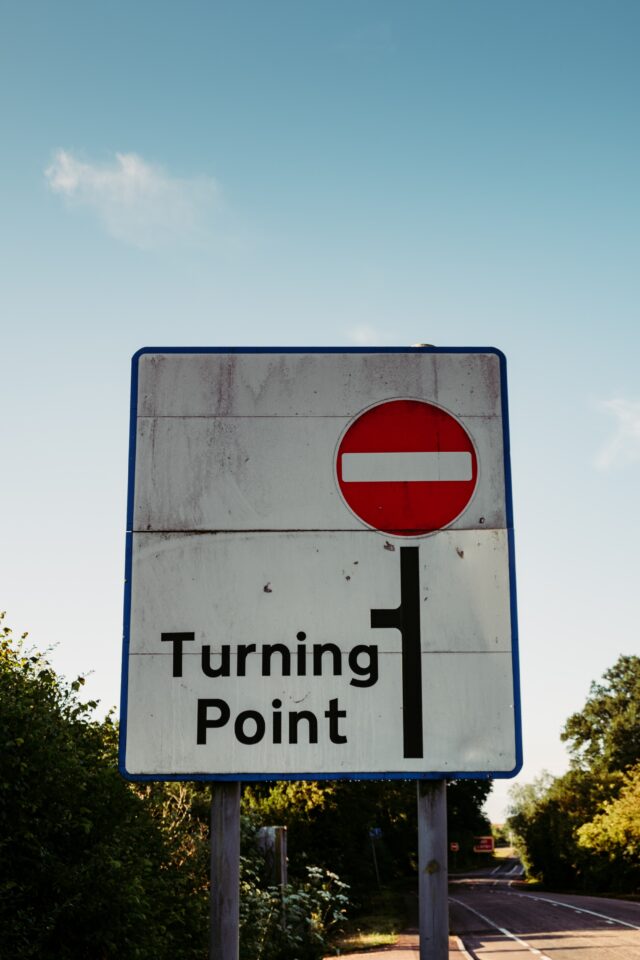 Road sign indicating no entry ahead and a turning point to the left