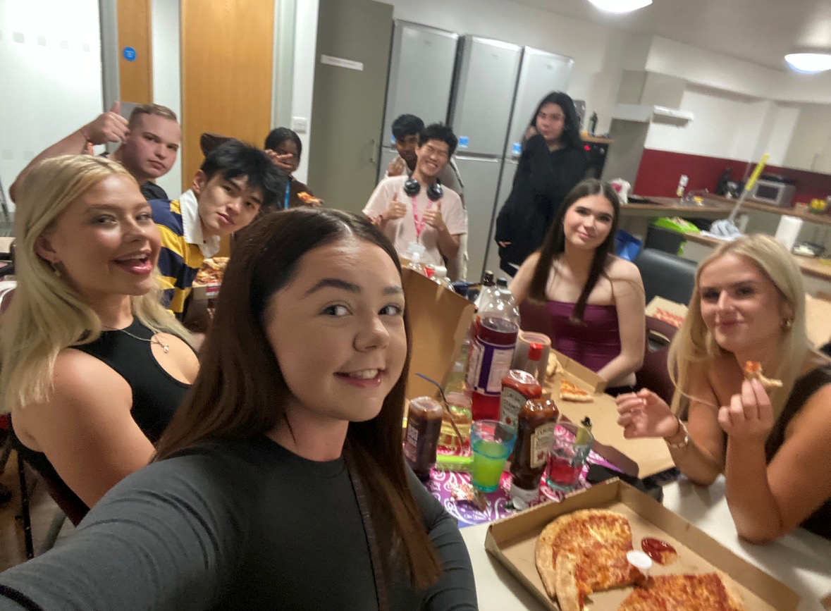 Em and her friends posing for the camera with pizza