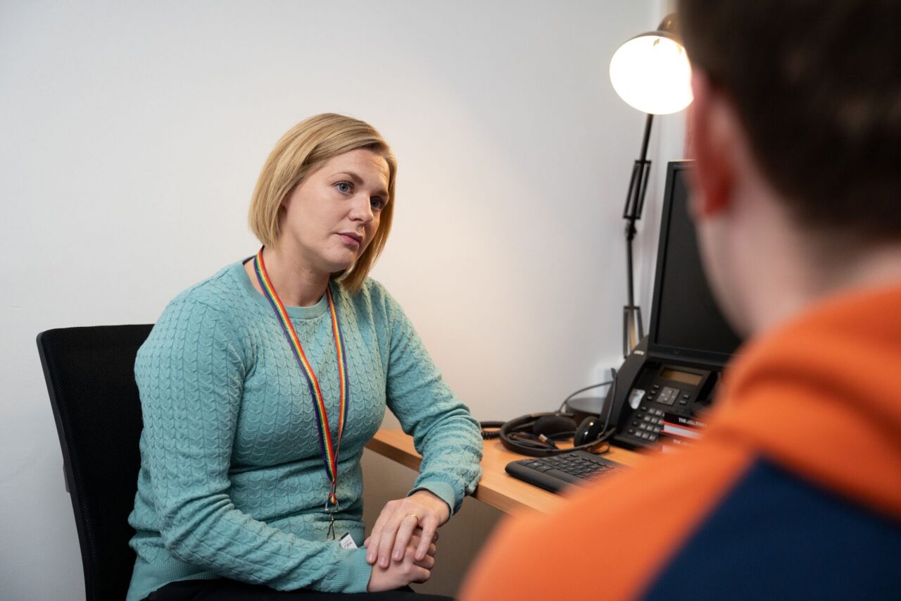 Member of staff listening to a student talking.